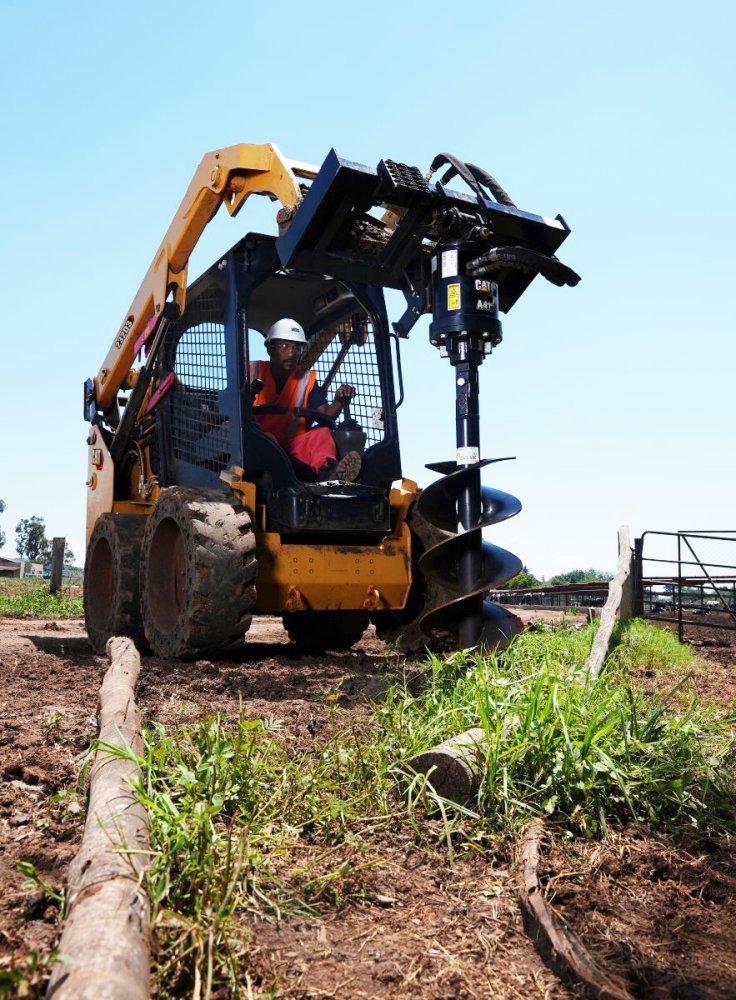 Skid Steer with Auger Putting In Fence