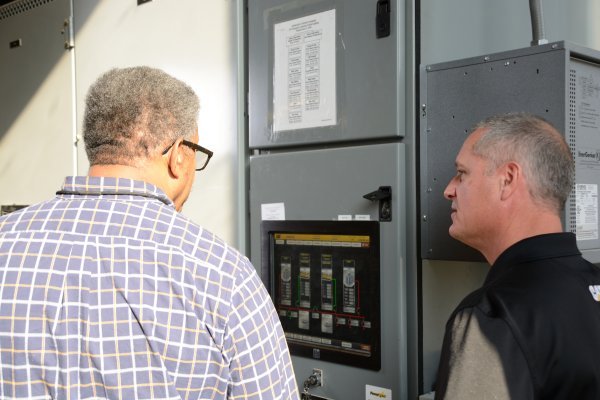 Men Standing in front of Airport Switchgear